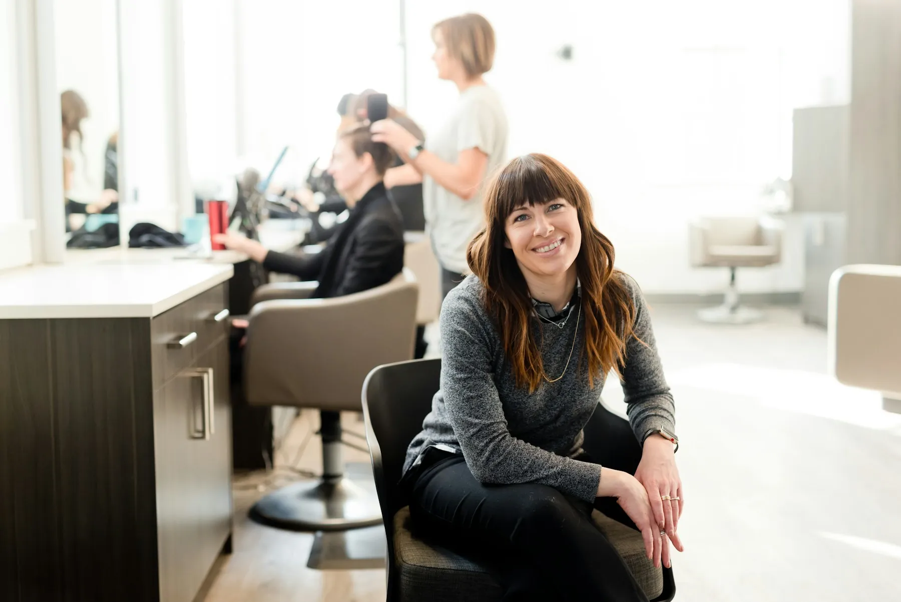 La coiffeuse sourit dans son salon