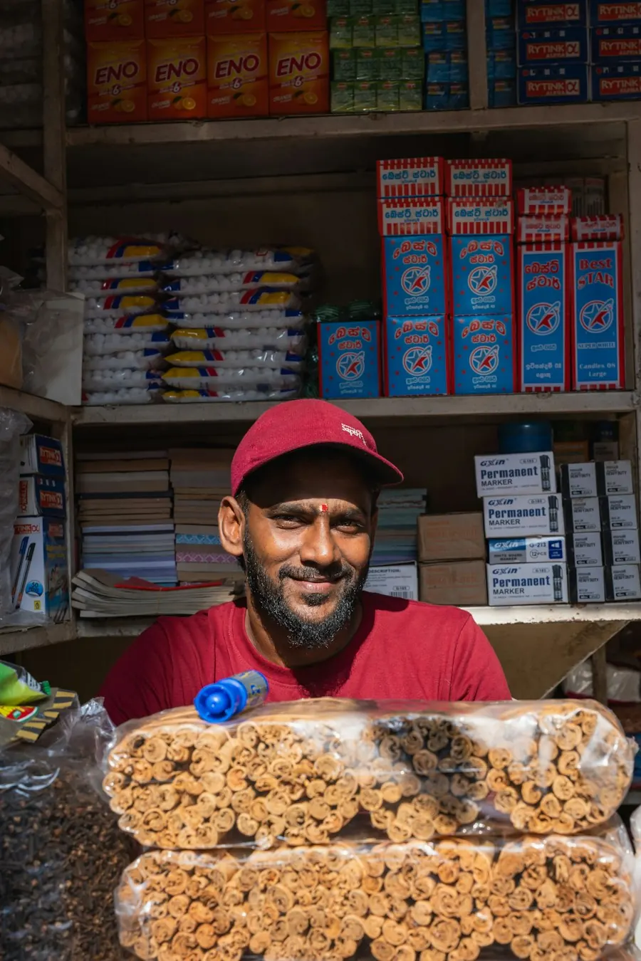 Un commerçant sourit derrière le comptoir de sa boutique