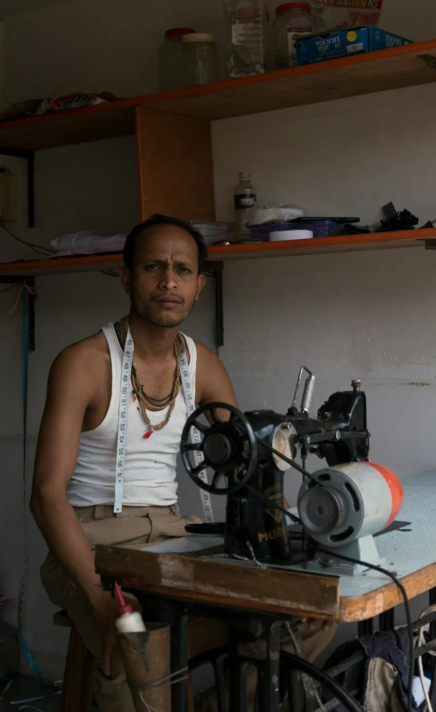 Un couturier devant sa machine à coudre