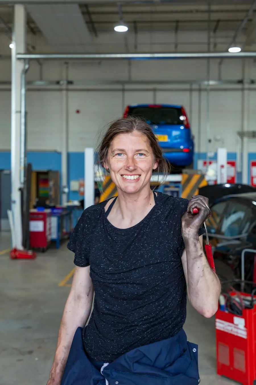 Une garagiste, clé à la main, dans son atelier