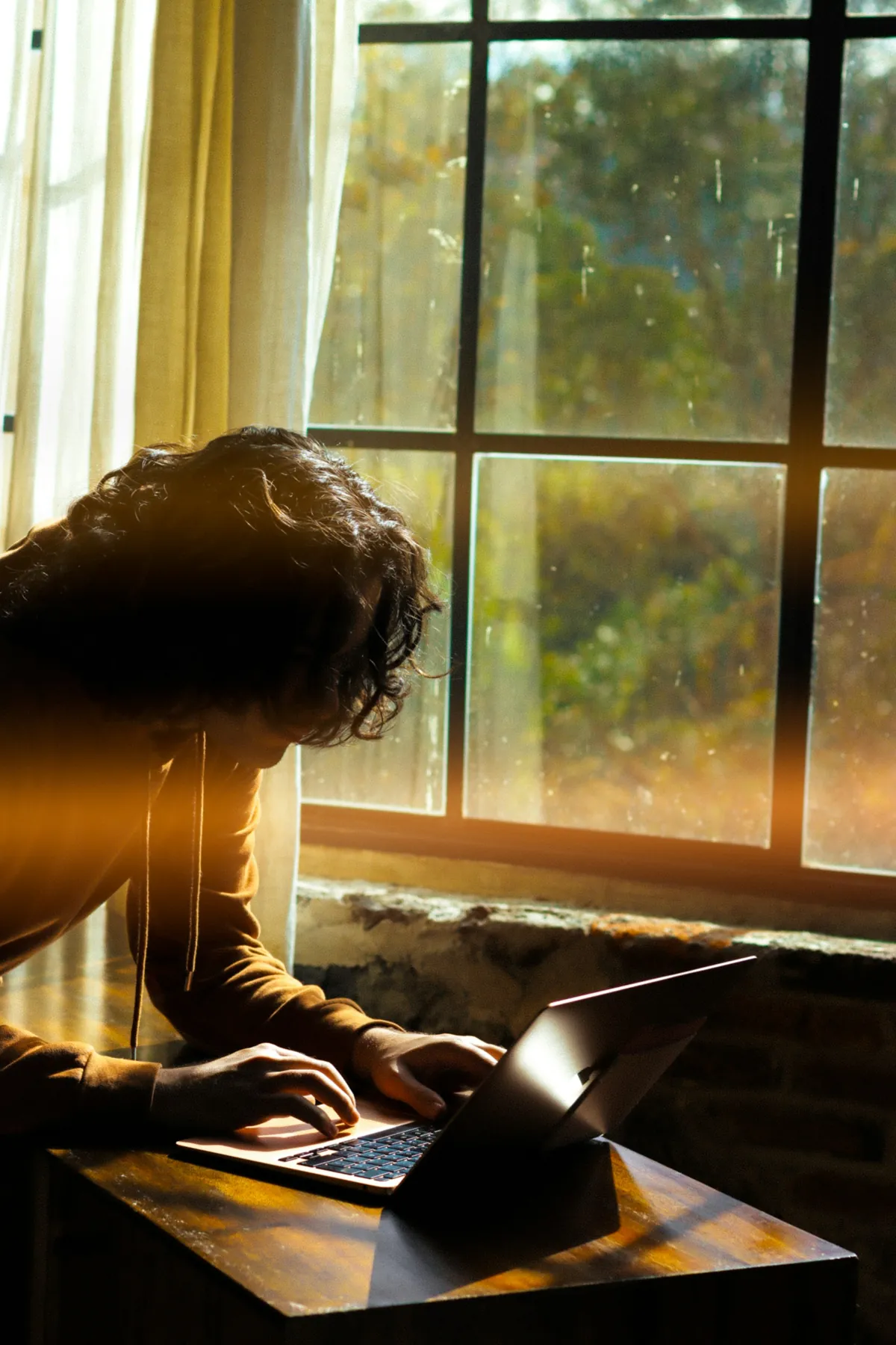 Une personne devant un ordinateur, en contre-jour