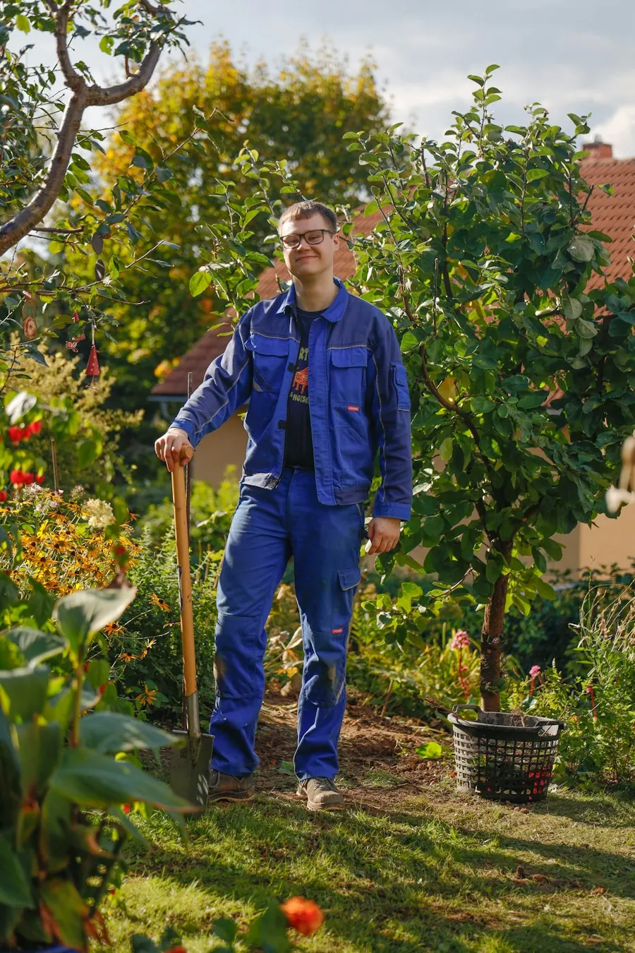 Un paysagiste, pelle à la main, dans un jardin